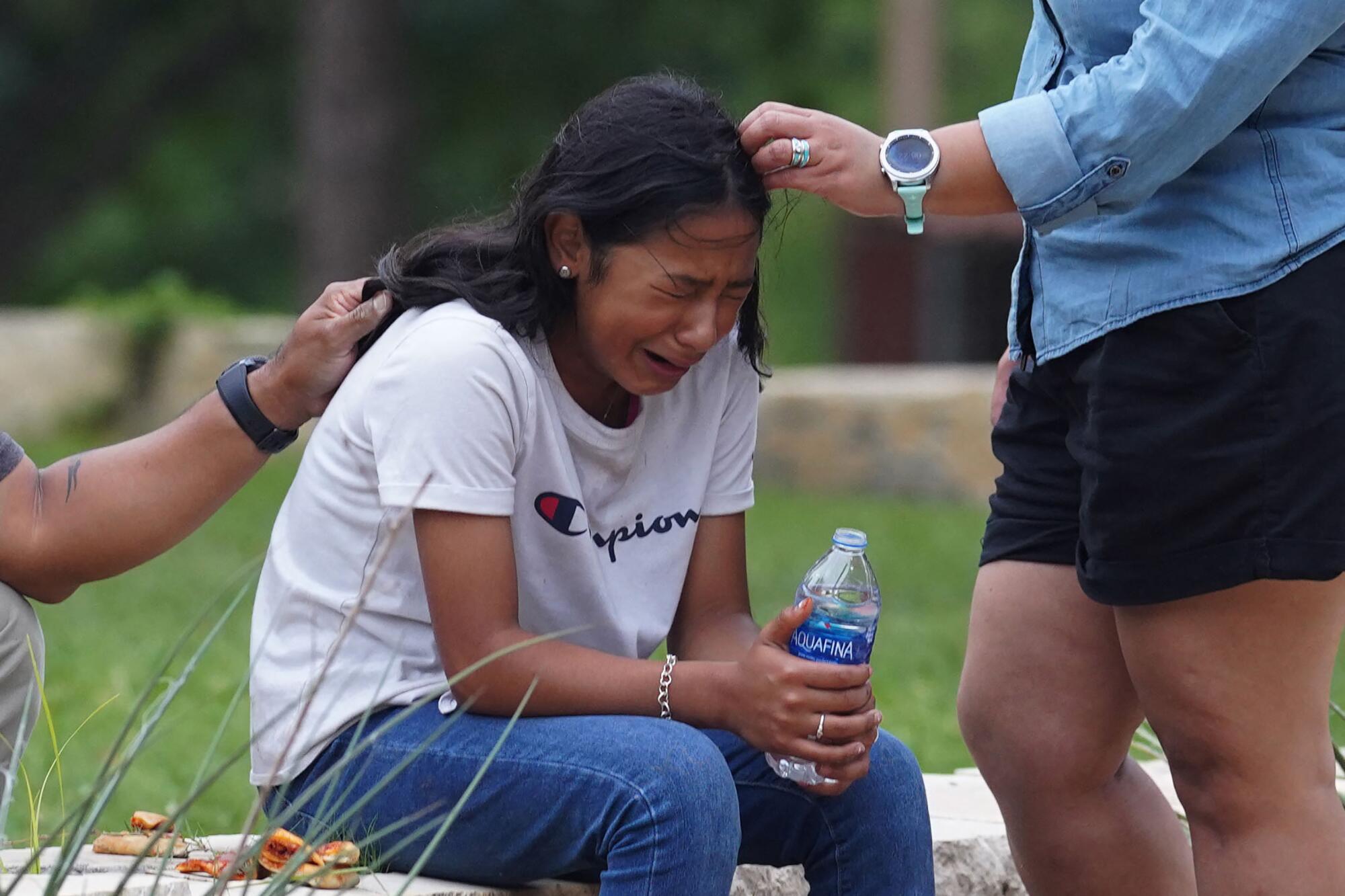 A girl is comforted outside the Sgt. Willie de Leon Civic Center in Uvalde, Texas.