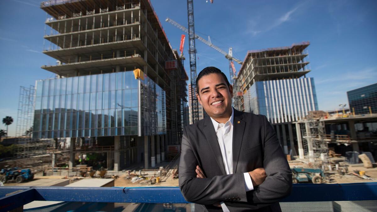 Long Beach Mayor Robert Garcia stands outside the Port of Long Beach headquarters, left, and City Hall, right, which are being developed by the city in partnership with a consortium of private companies.