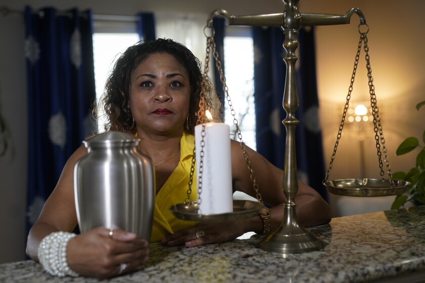 Daphne Bolton holds an urn containing the ashes of her brother at her home on Monday, May 31, 2021, in Charlotte, N.C. Bolton's brother, Johnny Lorenzo Bolton, a 49-year-old Black man was shot shoot to death by a Cobb County Sheriff's Office SWAT team member serving a search warrant last December. (AP Photo/Chris Carlson)