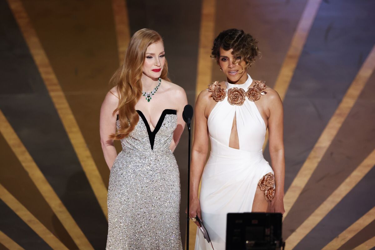 Two women onstage in formal gowns