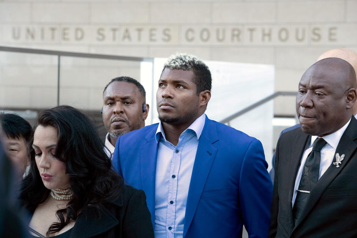 Yasiel Puig at a news conference surrounded by four other people. 