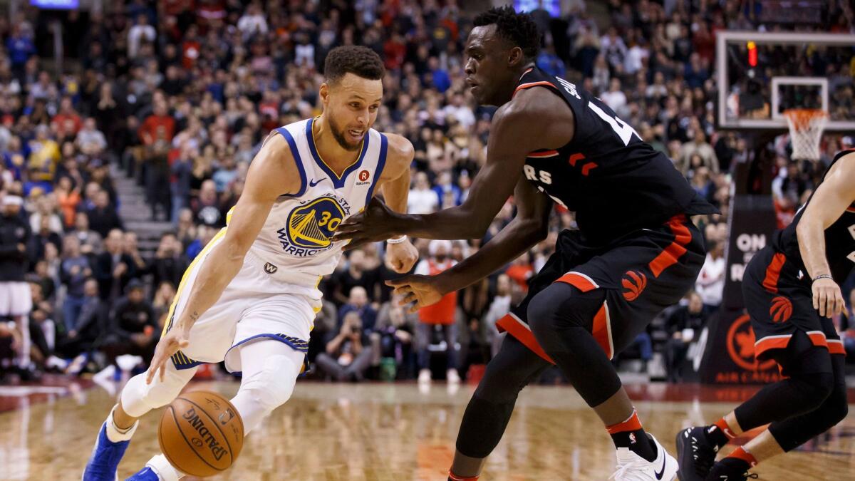 Golden State Warriors guard Stephen Curry drives to the basket against Toronto Raptors forward Pascal Siakam during the second half.