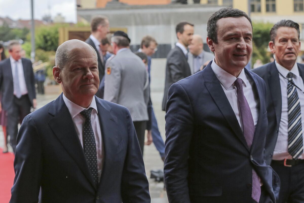 German Chancellor Olaf Scholz, left, walks with Kosovo Prime Minister Albin Kurti, in the Kosovo capital Pristina, Friday, June 10, 2022. Scholz is on a one day visit to the country. (AP Photo/Visar Kryeziu)