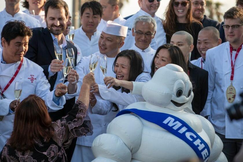 HUNTINGTON BEACH, CALIF. -- MONDAY, JUNE 3, 2019: n/naka, Culver City chef Niki Nakayama, center, and her partner and sous chef Carole Iida-Nakayama, center right, raise their glasses with the Michelin mascot and fellow chefs (some receiving one and two stars) after she and her restaurant was awarded a Michelin two-star status during a live reveal of the inaugural 2019 Michelin Guide California selection dining guide announcement at the Pasea Hotel & Spa in Huntington Beach, Calif., on June 3, 2019. (Allen J. Schaben / Los Angeles Times)