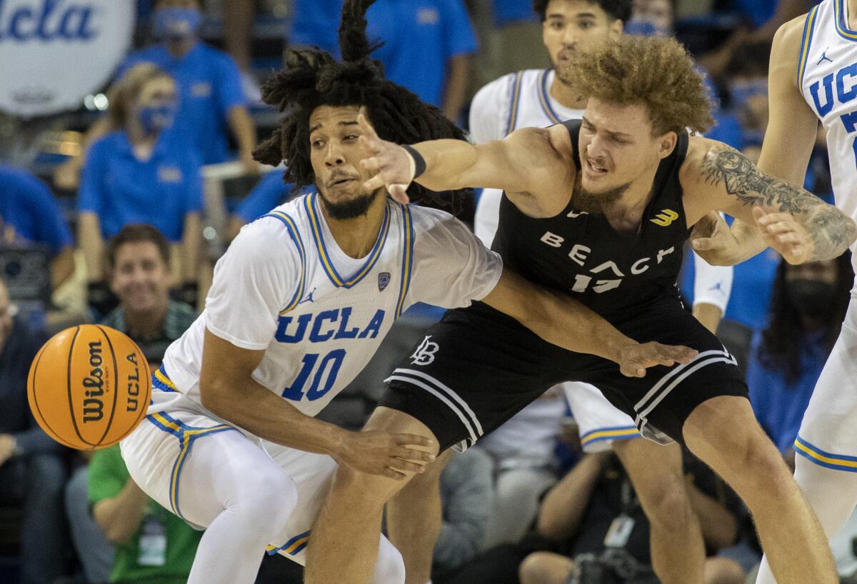 Long Beach State's Romelle Mansel, right, loses the ball as he battles UCLA's Tyger Campbell.