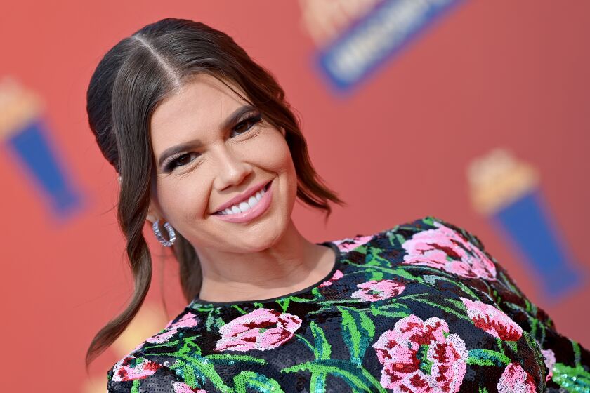 Woman, Chanel West Coast smiling in floral dress
