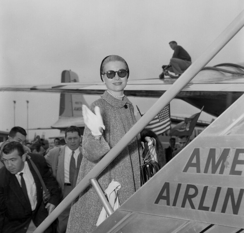 A woman goes up stairs to board a plane.