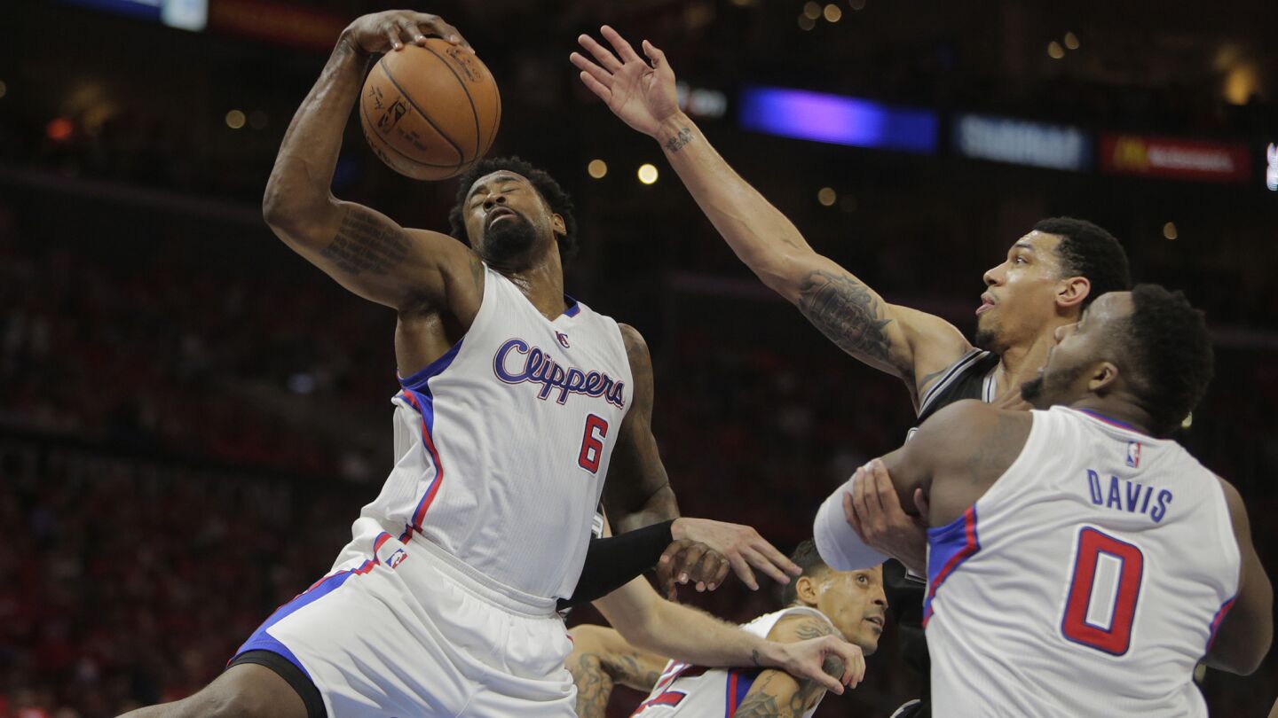 Clippers center DeAndre Jordan, left, grabs a rebound in front of teammate Glen Davis, right, and San Antonio Spurs guard Danny Green during the first half of Game 7 of the Western Conference quarterfinals at Staples Center on May 2, 2015.