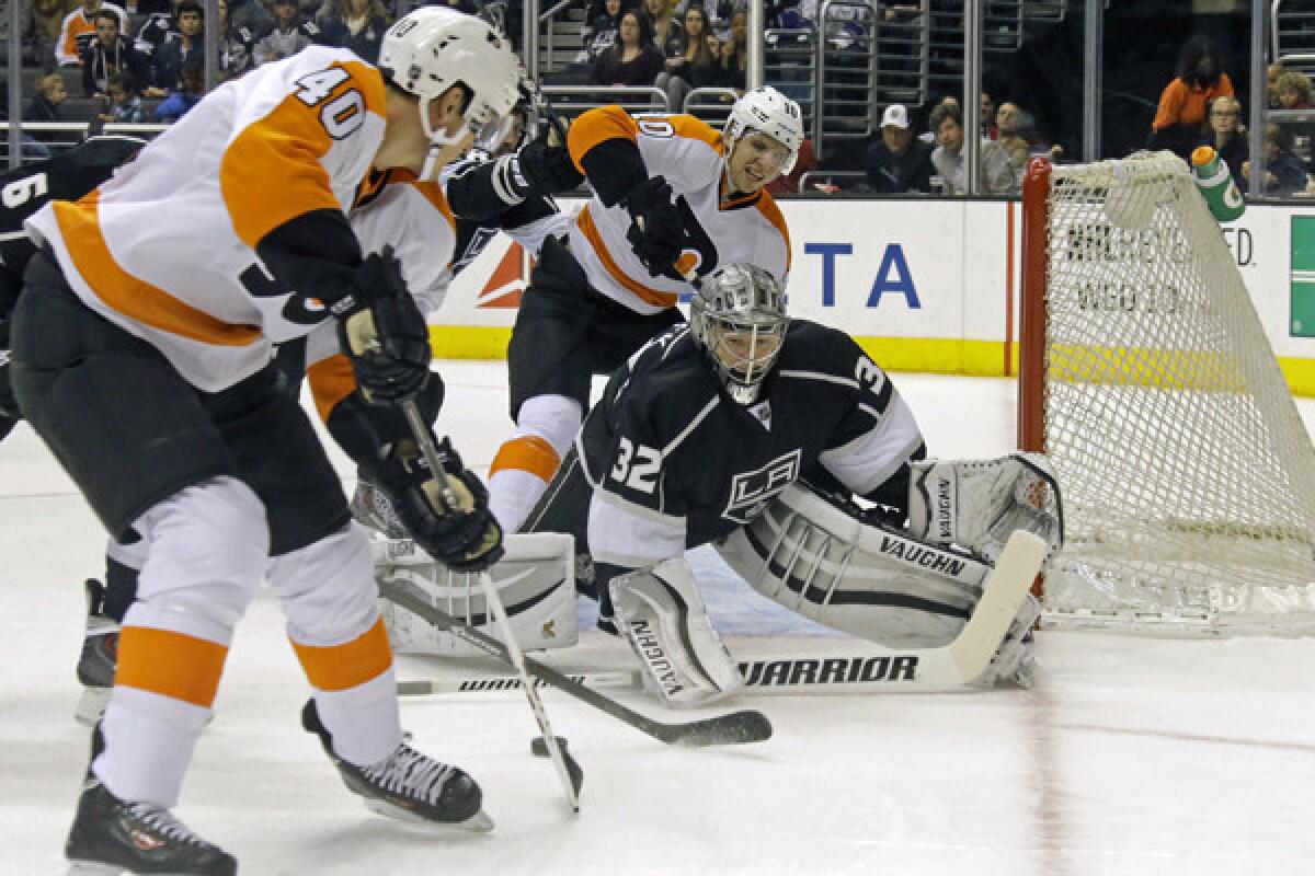 Kings goalie Jonathan Quick stays in front of Philadelphia Flyers center Vincent Lecavalier, left, as Brayden Schenn looks on during the first period of the Kings' 2-0 loss Saturday.