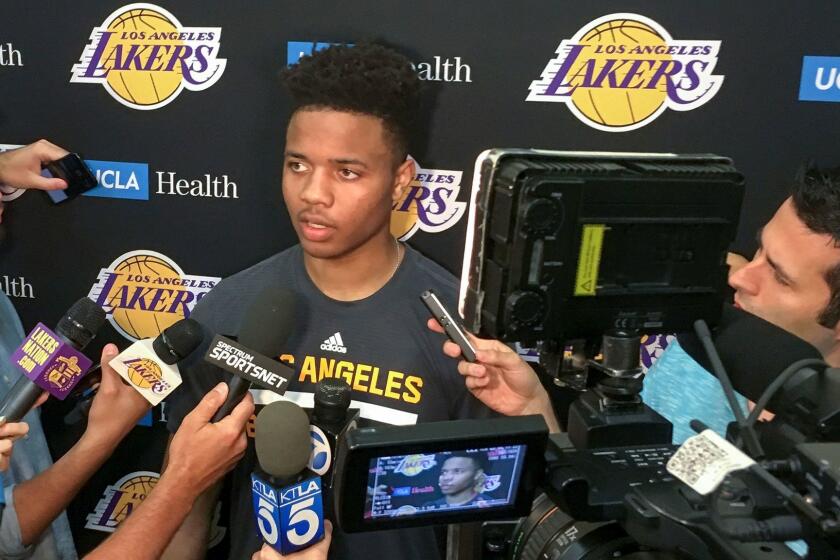 Markelle Fultz, center, speaks with reporters after his private workout with the Los Angeles Lakers at NBA basketball team's training complex Thursday, June 15, 2017, in El Segundo, Calif. The University of Washington guard could be the No. 1 pick in the NBA draft by the Boston Celtics, or he could be available to the Los Angeles Lakers with the second overall pick. (AP Photo/Greg Beacham)