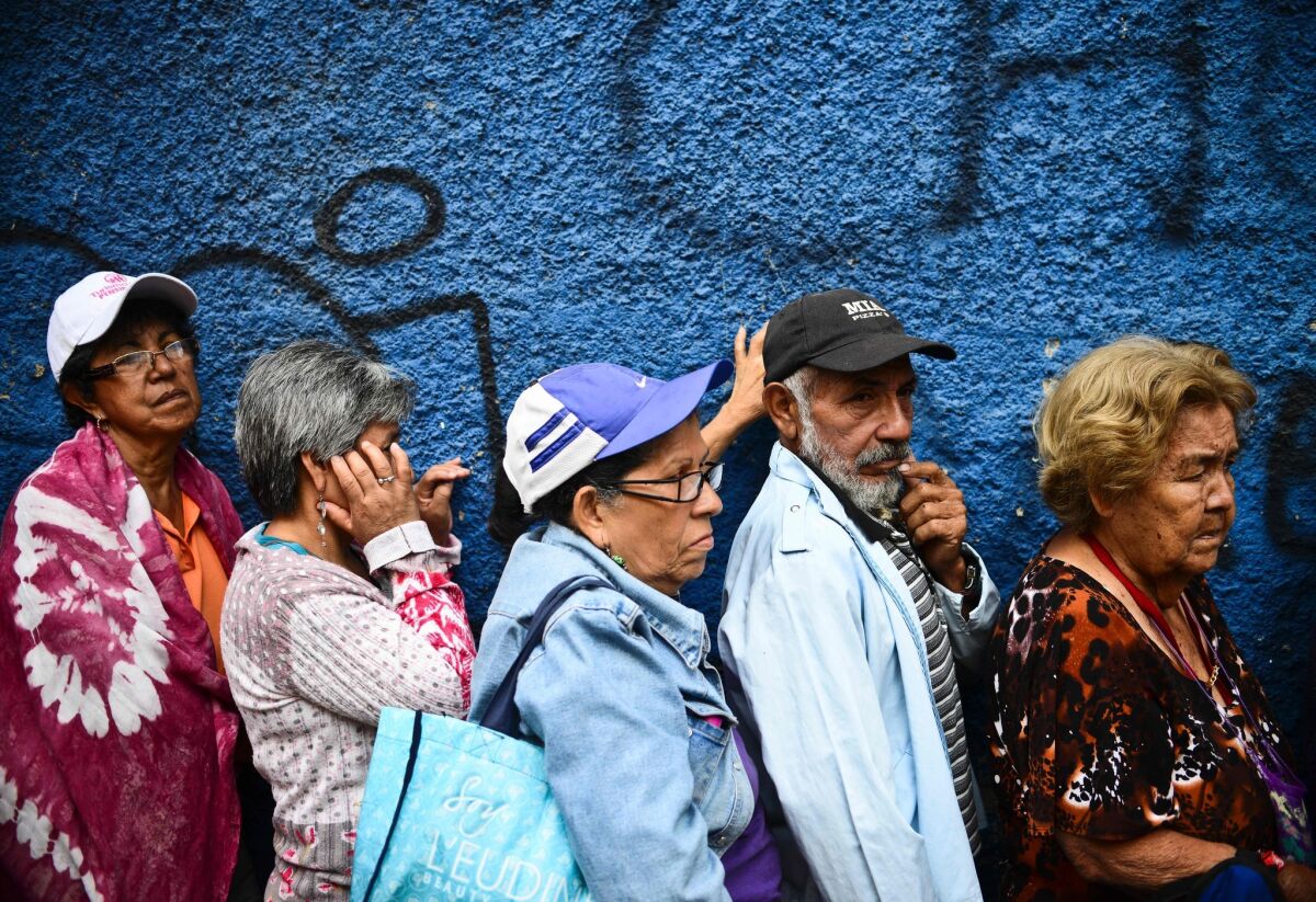People line up to buy food in the Lidice neighborhood of Caracas, Venezuela.