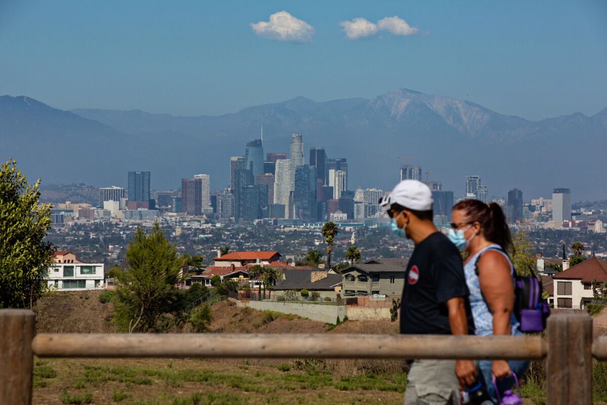 Masked hikers trek through Kenneth Hahn park in Los Angeles. 