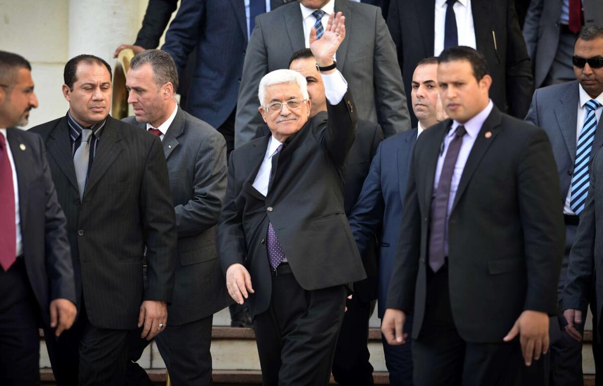 Palestinian Authority President Mahmoud Abbas waves as he leaves the Arab foreign ministers' urgent meeting at the Arab League headquarters in Cairo on Thursday to discuss in part the Palestinian-Israeli conflict.