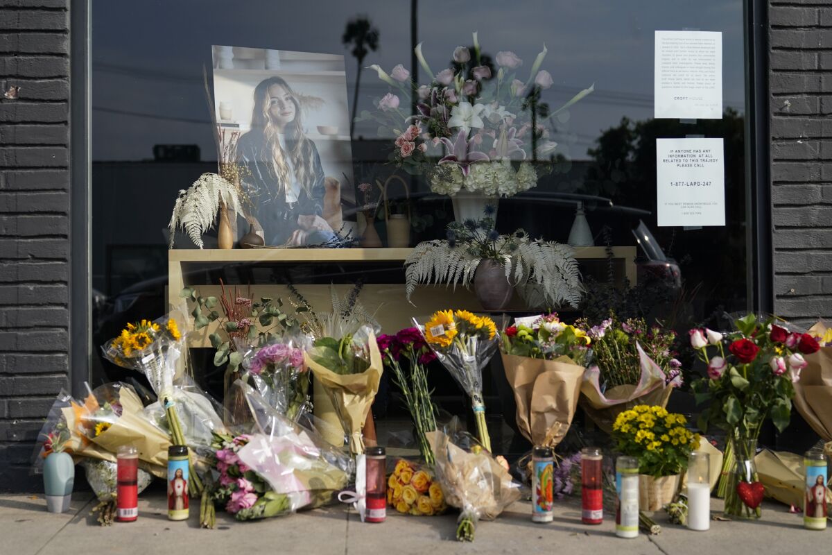 Flowers and candles are placed outside store in honor of Brianna Kupfer, pictured, on Tuesday, Jan. 18, 2022, in Los Angeles. The Los Angeles Police Department, West Bureau Homicide detectives are investigating the murder of Kupfer, a 24-year-old Pacific Palisades resident, who was killed at a business in the 300 block of North La Brea Avenue on Jan. 13. (AP Photo/Ashley Landis)