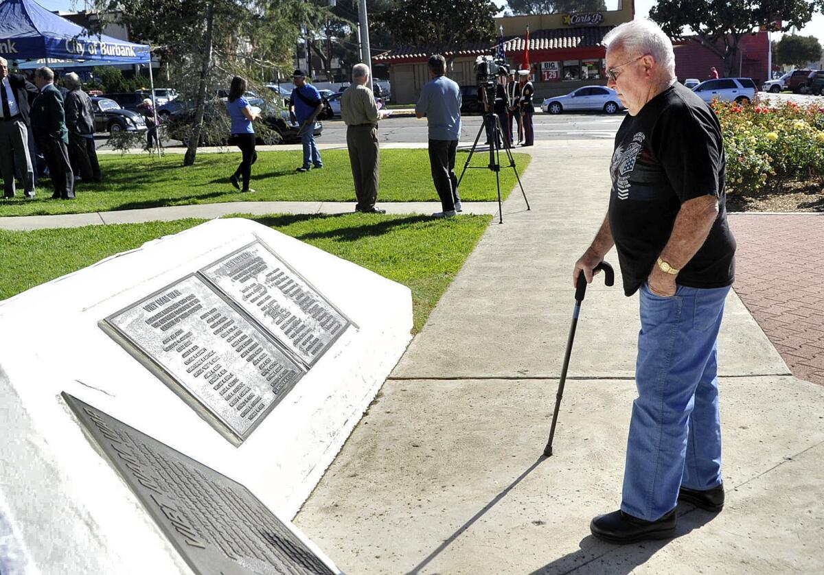 Jerry Glenn, of North Hills, who served in the Korean War, looks at the names of the soldiers on the Vietnam war memorial at the Veterans Day Ceremony at the McCambridge Park War Memorial in Burbank on Monday, November 11, 2013.