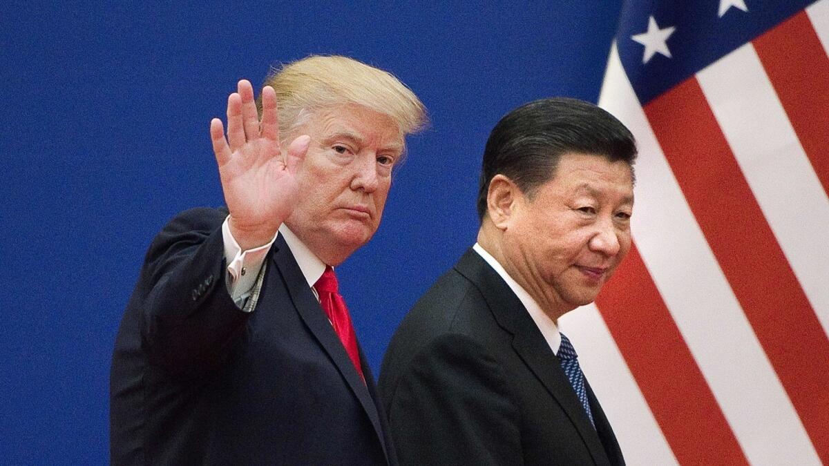 President Trump and China's President Xi Jinping leave a meeting together in Beijing in 2017. Their trade war continues.