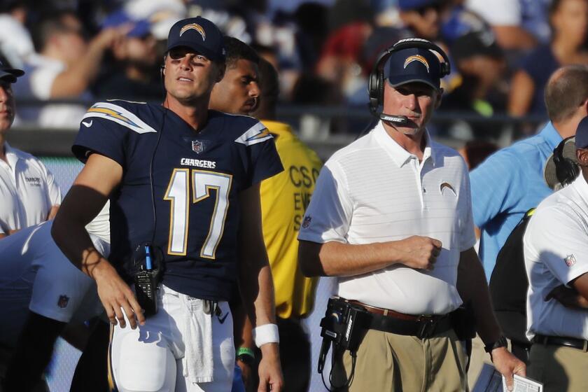 LOS ANGELES, CALIF. -- SATURDAY, AUGUST 26, 2017: Chargers quarterback Philip Rivers, left, and offensive coordinator Ken Whisenhunt, right, watch from sideline as the Los Angeles Rams play the Los Angeles Chargers at the Coliseum in Los Angeles, Calif., on Aug. 26, 2017. (Brian van der Brug / Los Angeles Times)