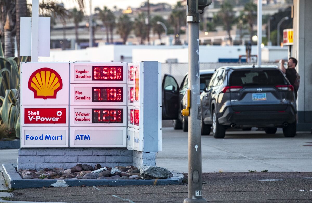 People stand near the pumps at a Shell gas station in San Diego on Tuesday, Sept. 27, 2022 in San Diego, CA. 