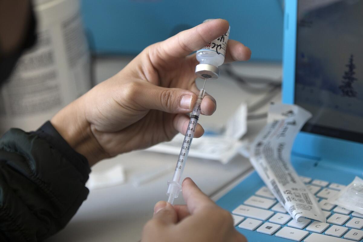 A nurse fills syringes with the Moderna COVID-19 vaccine