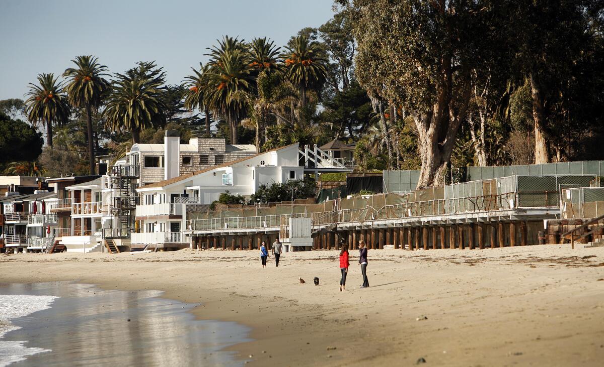 People walk along the beach in Montecito last week near the shuttered Miramar hotel site. The Montecito Planning Commission on Wednesday gave L.A. shopping mall developer Rick Caruso approval to build a 170-room, cottage-style luxury resort on the site 100 miles northwest of Los Angeles.