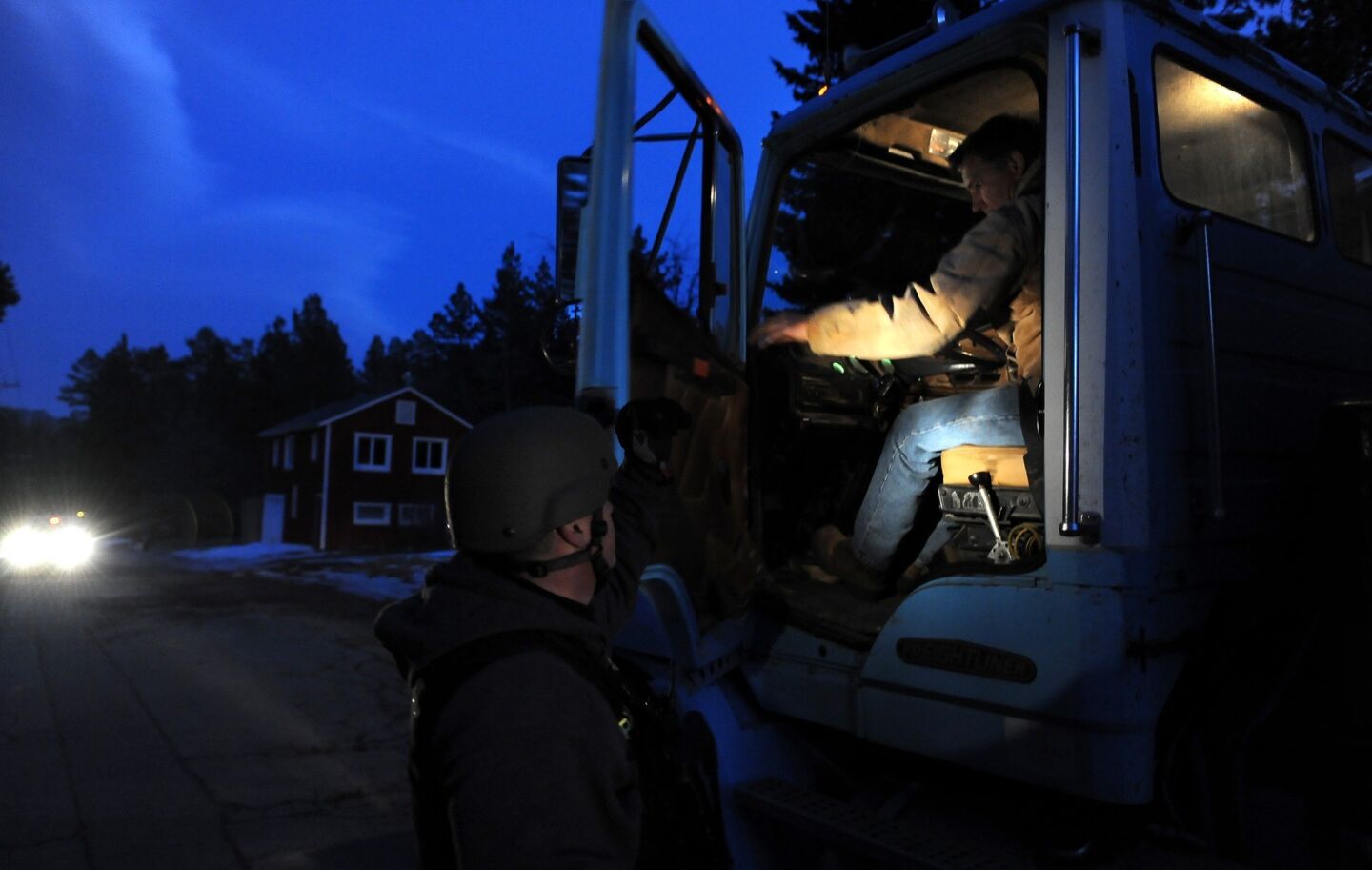 A police officer checks the cab of a truck along Switzerland Avenue in Big Bear Lake for shooting suspect Christopher Dorner.