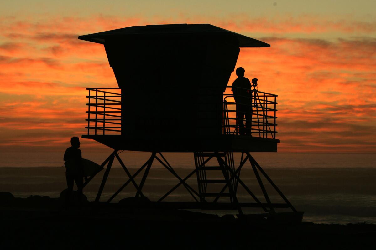 2006 photo of surfers at Cardiff State Beach watch the sunset.