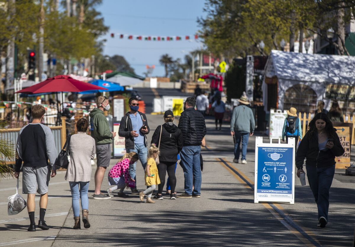 People walk on Main St. in Ventura.