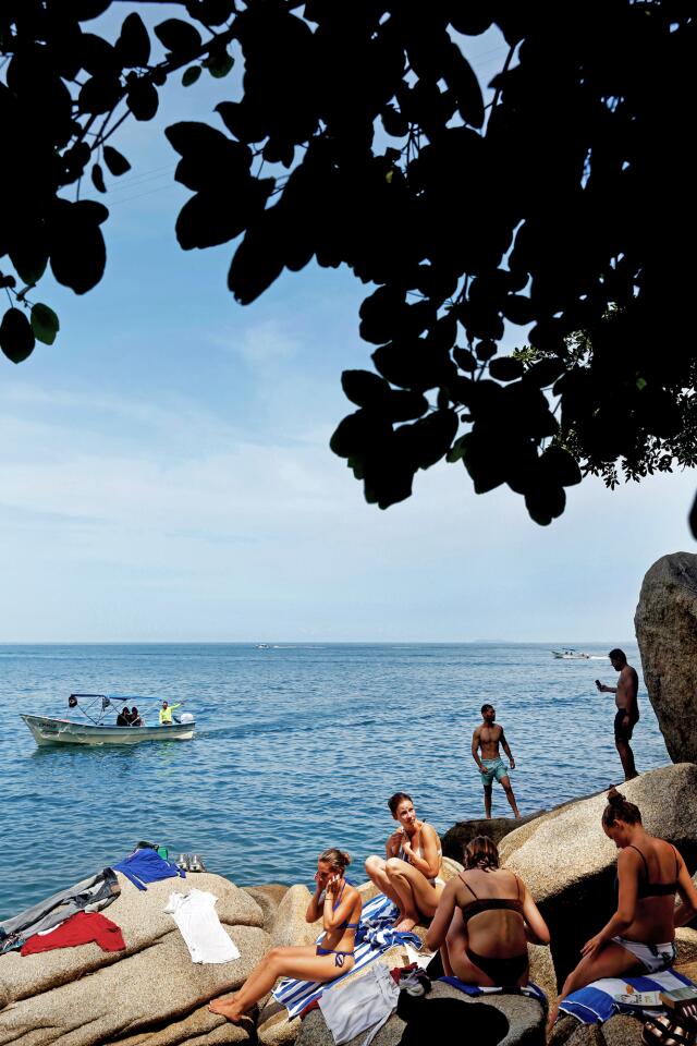 PUERTO VALLARTA, MEX-SEPTEMBER 1, 2019: Giodana Muller, Kim Schwartau, Weibke Hennig and Greta Alschnes, left to right, of Germany, relax on the rocks at Colomitos Cove on September 1, 2019 in Puerto Vallarta, Mexico. Colomitos Cove is about 45 minutes from the start of the trail. (Photo By Dania Maxwell / Los Angeles Times)