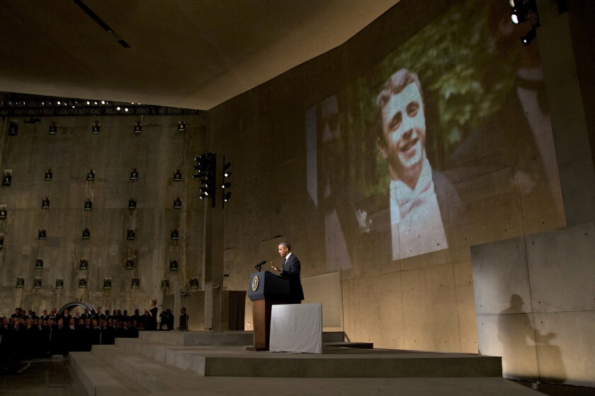 President Obama speaks at the dedication of the 9/11 Memorial Museum as a photo of Welles Crowther, who died helping rescue people in the Sept. 11, 2001, terror attacks, is displayed on a screen behind him.