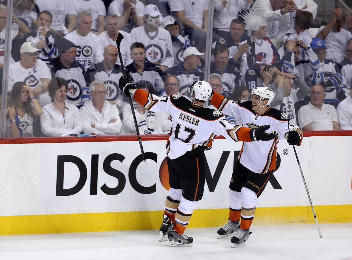 Ducks center Ryan Kesler celebrates with teammate Jakob Silfverbeg after tying the score, 4-4, against the Jets with a goal in the third period of Game 3.