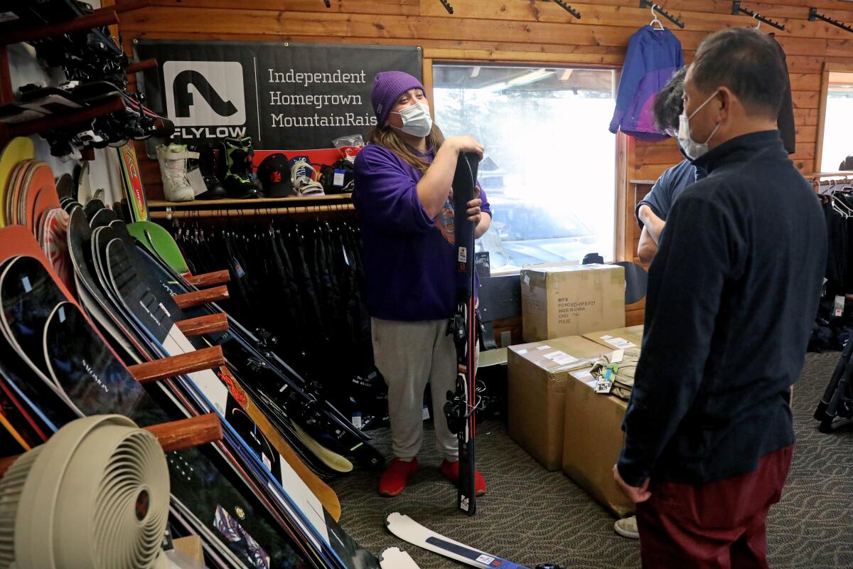 Customers are helped at a ski and snowboard rental shop.