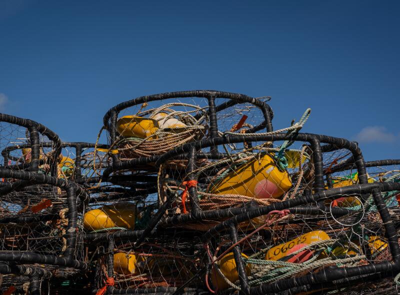 Crab pots are piled on the deck of a commercial fishing boat in Half Moon Bay.