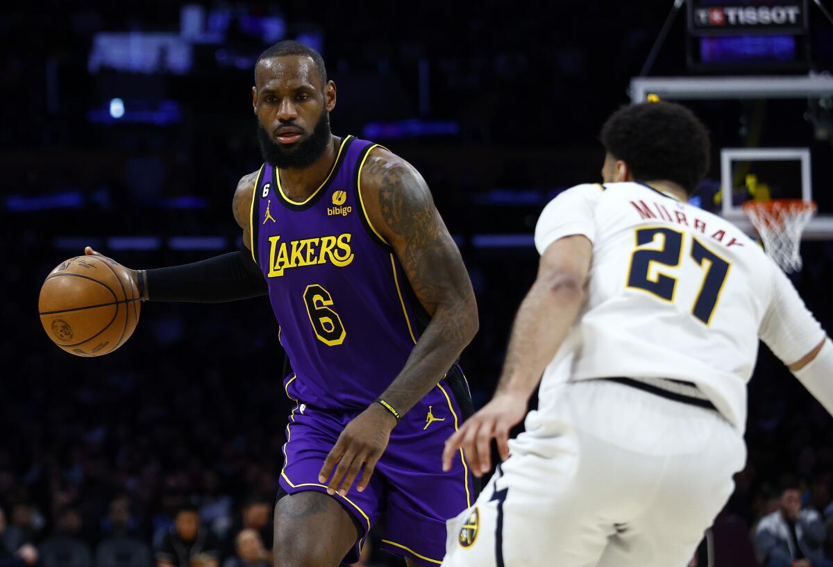 Lakers forward LeBron James drives against Nuggets guard Jamal Murray.
