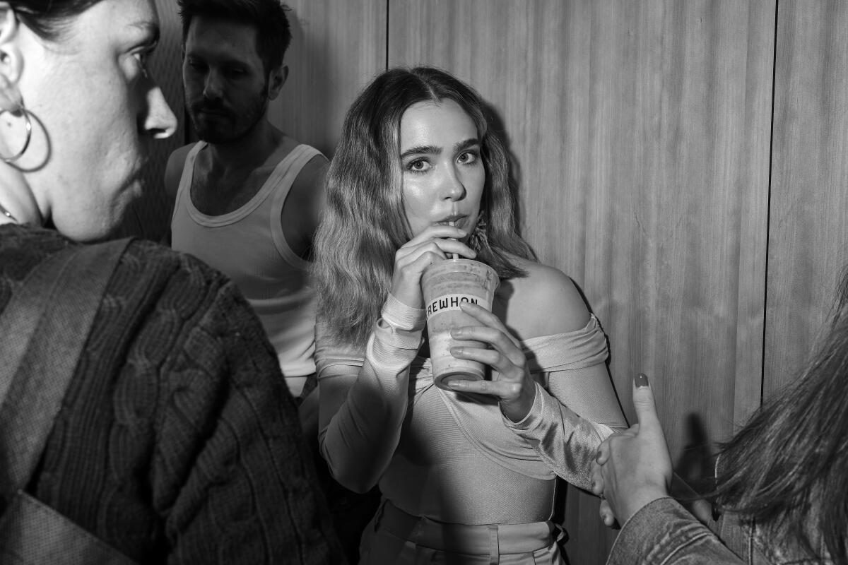 Haley Lu Richardson drinks a smoothie on a break during a photo shoot.