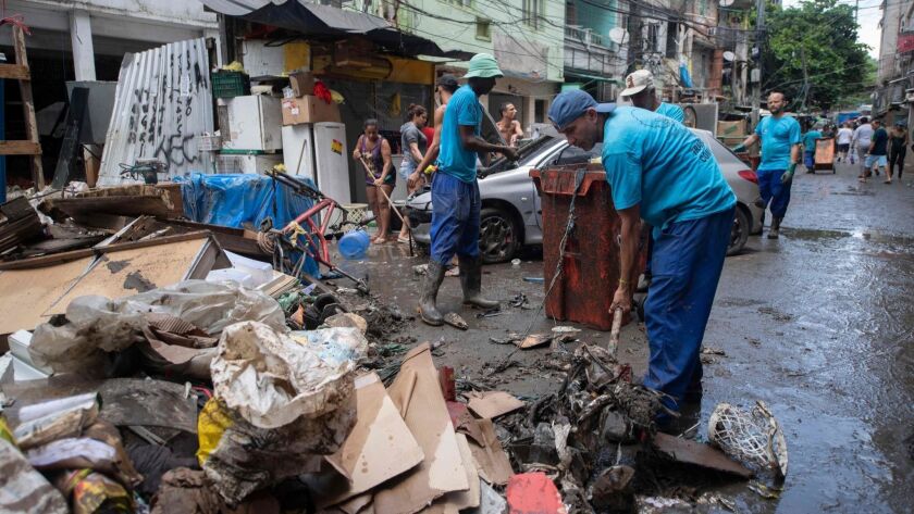 Residents clean up Thursday after a storm in the Rocinha favela in Rio de Janeiro.