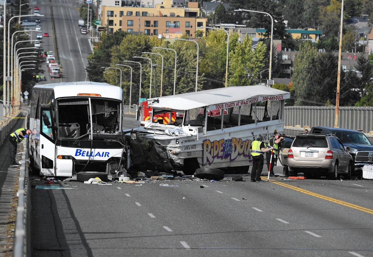 Authorities investigate the scene of a collision between a sightseeing duck boat and a charter bus on Aurora Bridge in Seattle. Four international students died in the Sept. 24 accident.