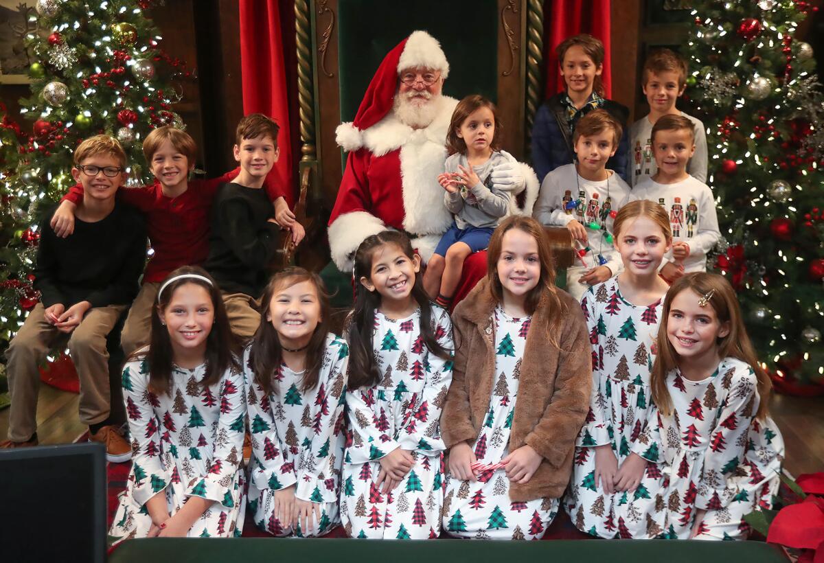 Groups of siblings get a picture with Santa at South Coast Plaza's Carousel Court on Dec. 7.