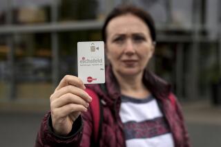 Erdina Laca, una solicitante de asilo de 45 años, muestra una tarjeta de pago especial del gobierno para dar subsidios a migrantes, en Eichsfeld, Alemania, el miércoles 24 de abril de 2024. (Foto AP/Ebrahim Noroozi)