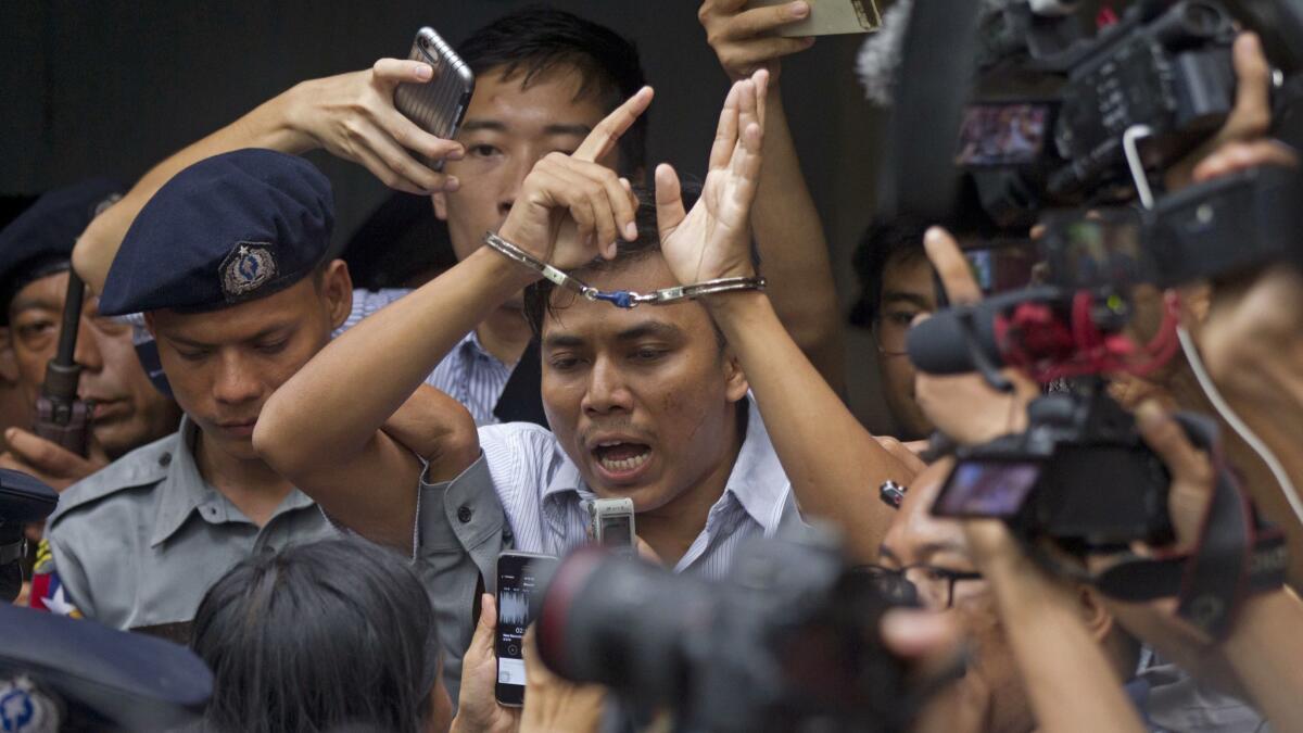 Reuters journalist Kyaw Soe Oo talks to journalists as he is escorted by police at court on Sept. 3, 2018, in Yangon, Myanmar.