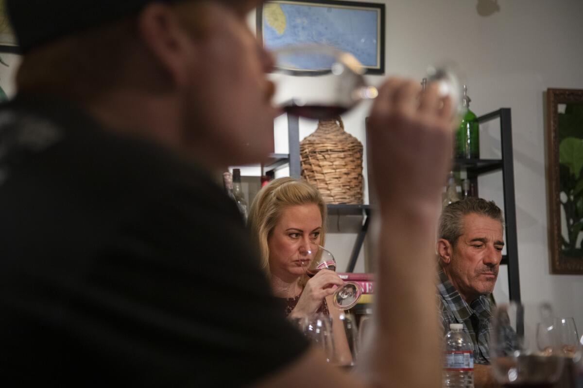 Peter Stolpman, left, Erin Kempe and Paolo Barbieri sample ocean-aged wine at Ocean Fathoms' Santa Barbara headquarters.