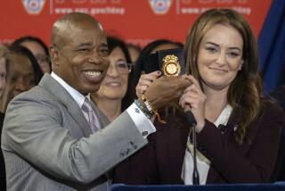 New York City Fire Commissioner Laura Kavanagh, right, and New York Mayor Eric Adams, left, hold an NYFD badge after Kavanagh was sworn in during a ceremony at FDNY Engine 33/Ladder 9, Thursday, Oct 27, 2022 in New York. (AP Photo/Yuki Iwamura)