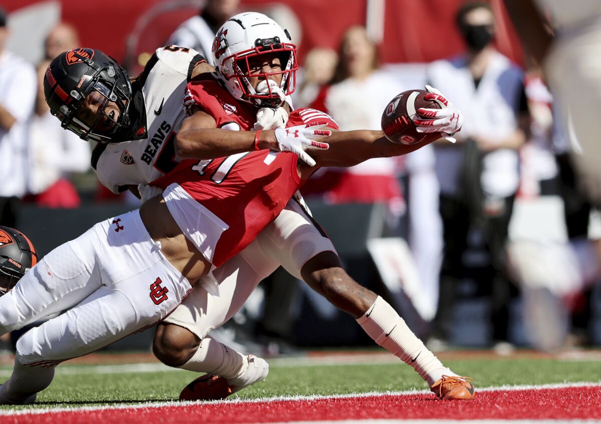 Utah wide receiver Devaughn Vele stretches the ball across the goal line for a touchdown with Oregon State defensive back Alex Austin hanging onto him during an NCAA college football game, Saturday, Oct. 1, 2022, in Salt Lake City. (Scott G Winterton,/The Deseret News via AP)