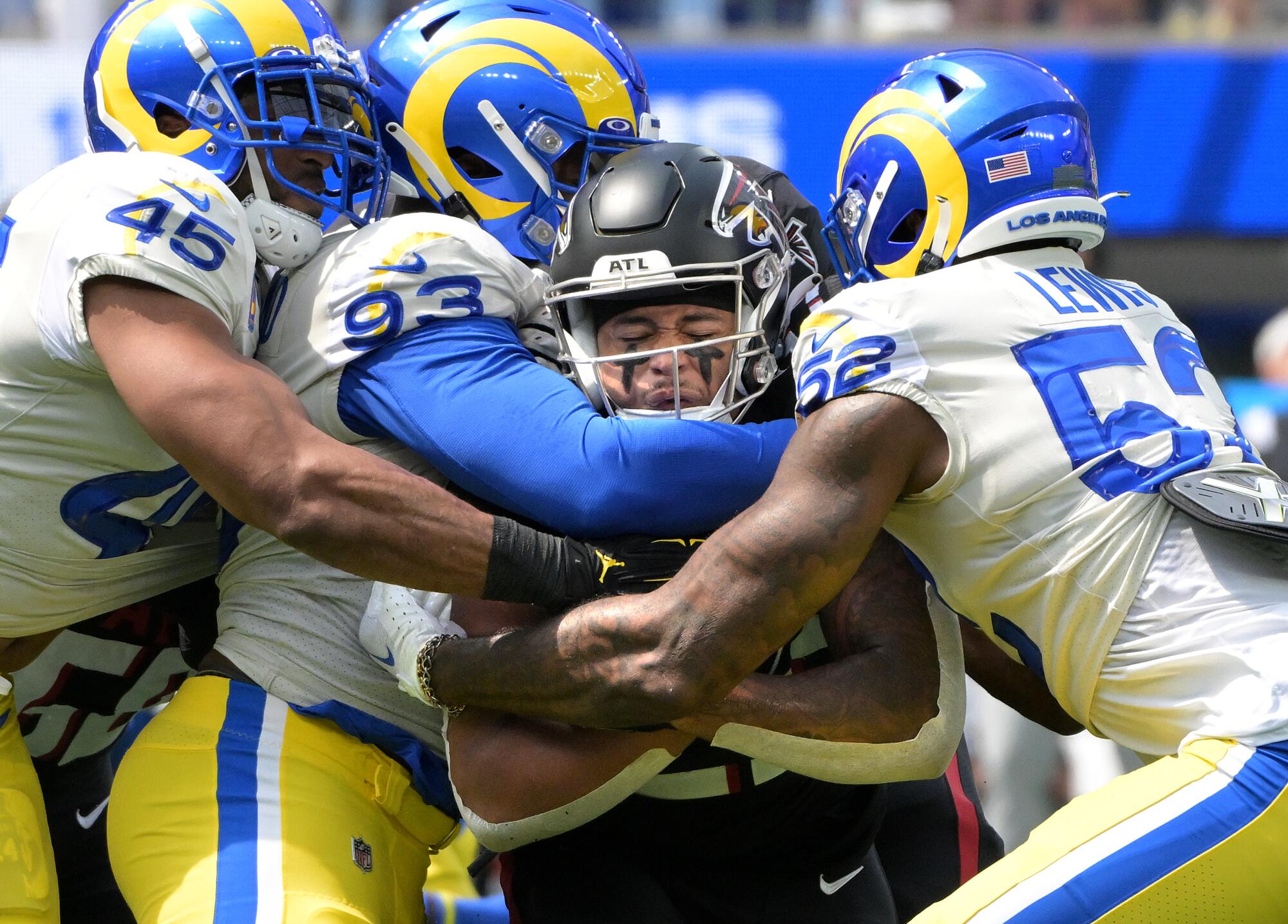 Rams defenders Bobby Wagner, Marquise Copeland and Terrell Lewis stop Falcons running back Tyler Allgeier.