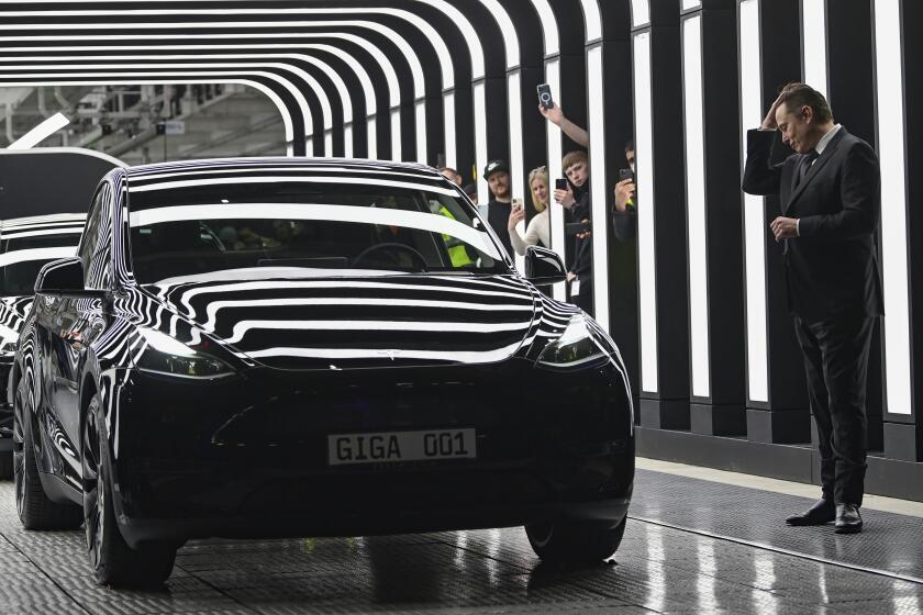Elon Musk, Tesla CEO, right, reacts relieved at the opening of the Tesla factory Berlin Brandenburg in Gruenheide, Germany, Tuesday, March 22, 2022. The first European factory in Gruenheide, designed for 500,000 vehicles per year, is an important pillar of Tesla's future strategy. (Patrick Pleul/Pool via AP)