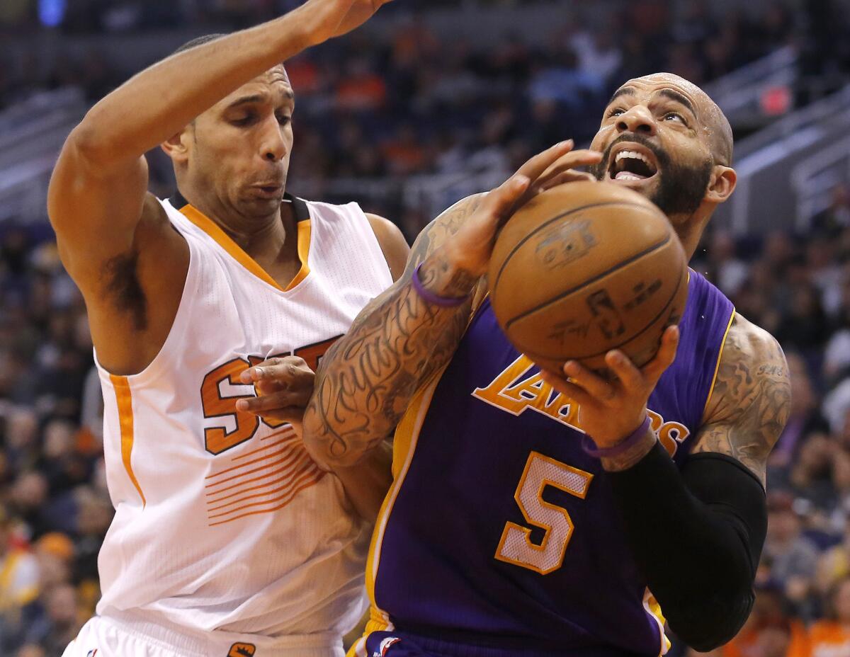 Lakers power forward Carlos Boozer tries to put up a shot with Suns power forward Brandan Wright draped on him.