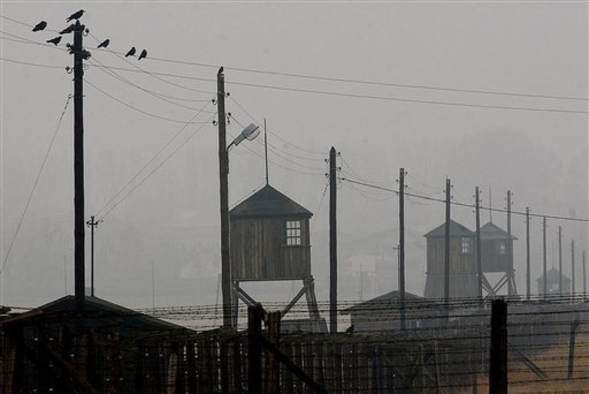 FILE - In this Nov. 9, 2005 file photo watch towers and the barbed wire fence of the former Nazi death camp Majdanek are pictured outside the city of Lublin in eastern Poland. Officials said on Tuesday, Aug. 10, 2010 a fire broke out overnight in one of barracks of the former Nazi death camp of Majdanek, destroying more than half of the building and about 10,000 shoes of Holocaust survivors. (AP Photo/Czarek Sokolowski, File)