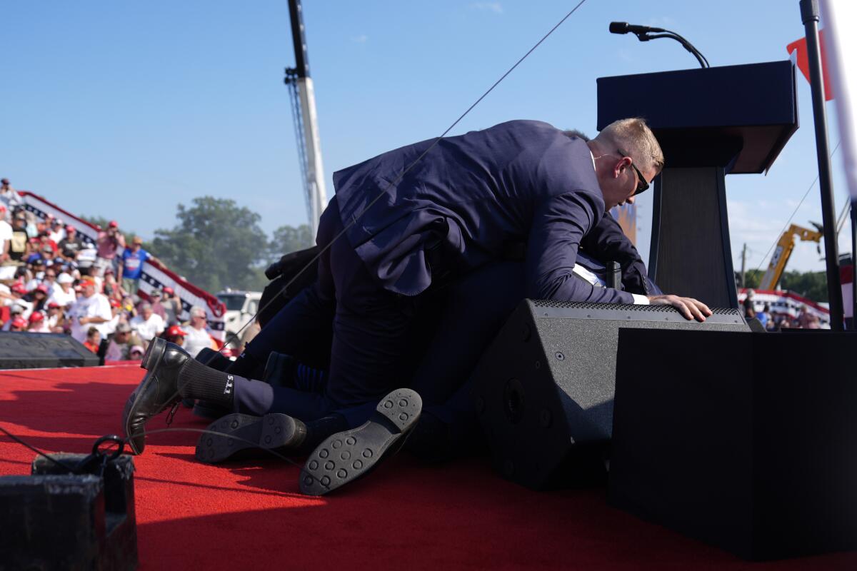 Republican presidential candidate Donald Trump is shielded by Secret Service agents at a rally in Butler, Pa.