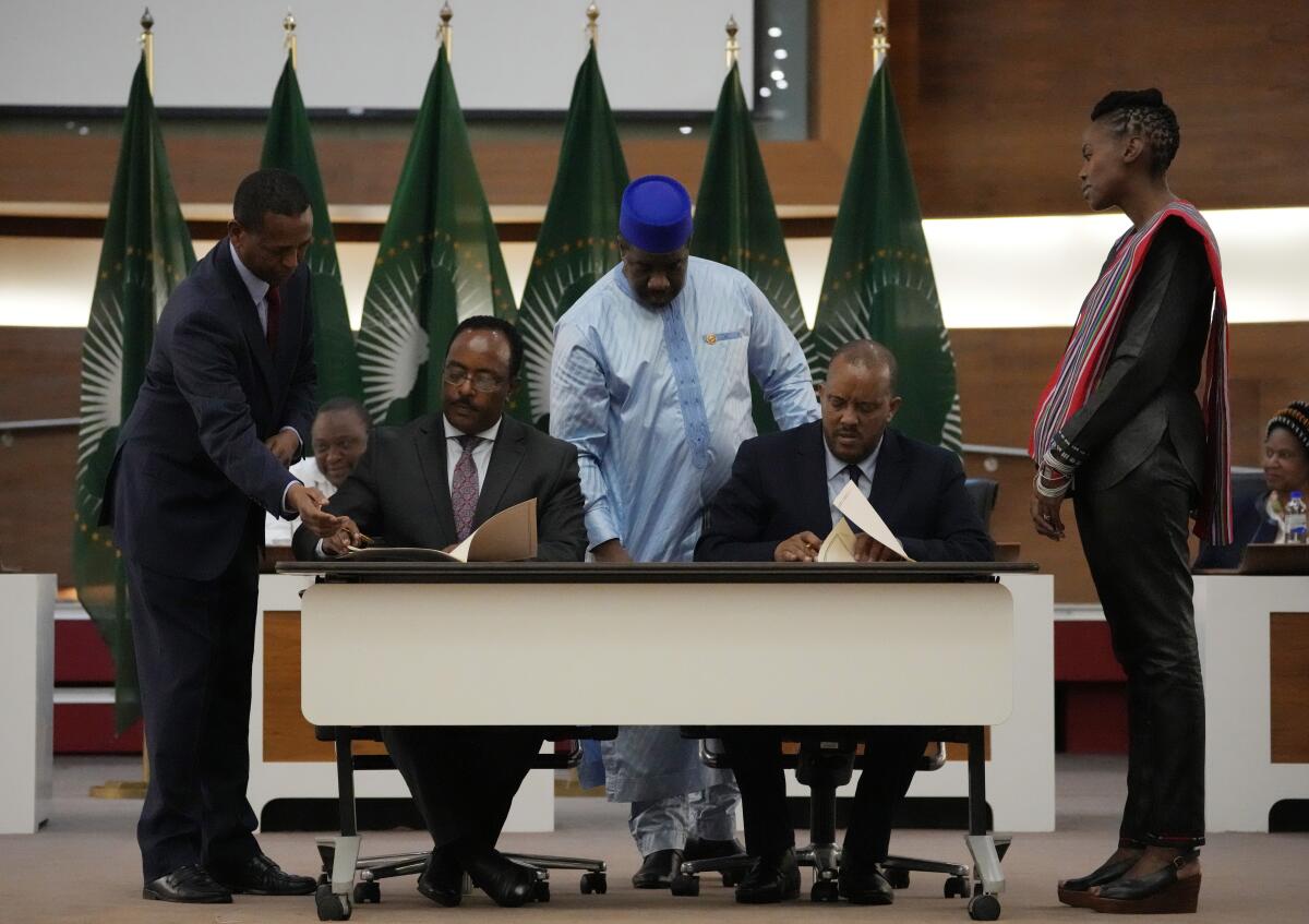 Ethiopian and Tigray leaders sign documents during the peace talks.