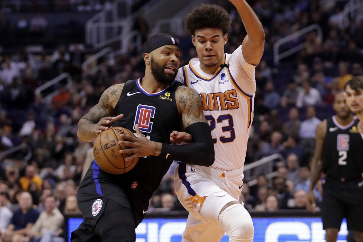 Clippers forward Marcus Morris drives as Phoenix Suns forward Cameron Johnson defends Feb. 26.
