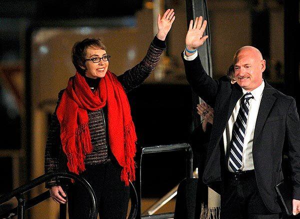 Rep. Gabrielle Giffords and her husband, former astronaut Mark Kelly, wave at the start of a memorial vigil remembering the victims and survivors one year after the Tucson shootings that wounded 13, including Giffords, and killed six.
